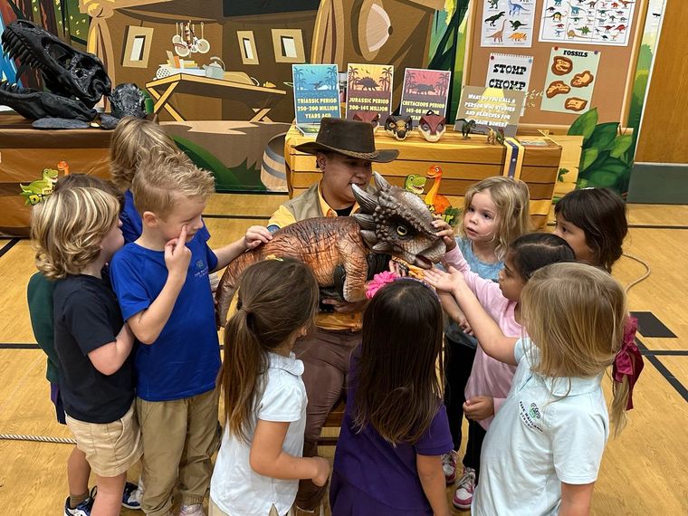 A group of kids gathers with a trainer at the Dino Research Center