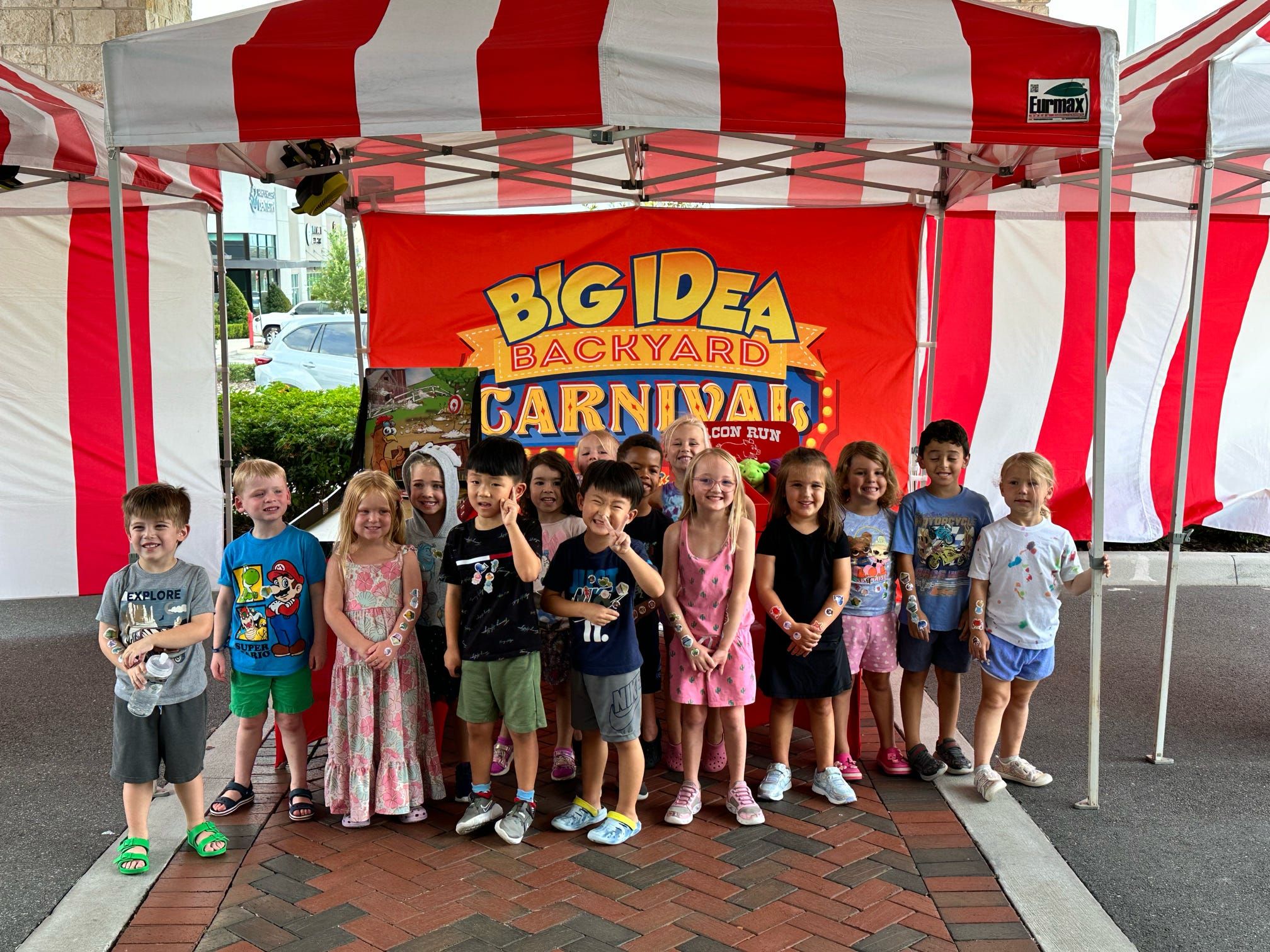 several kids under a red and white striped tent at a carnival in Tampa.