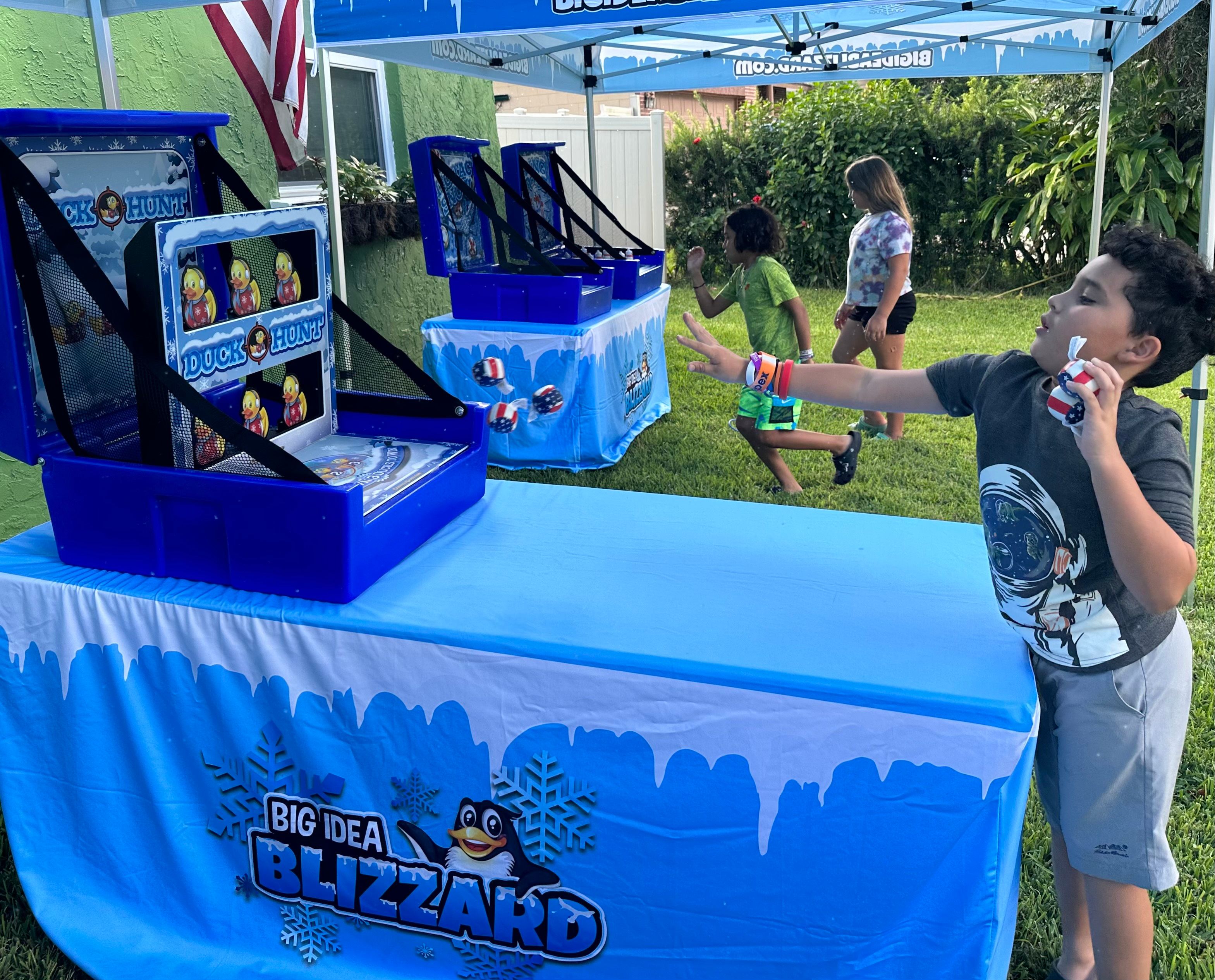 A boy plays Duck Hunt at a table dressed in the Blizzard penguin cover