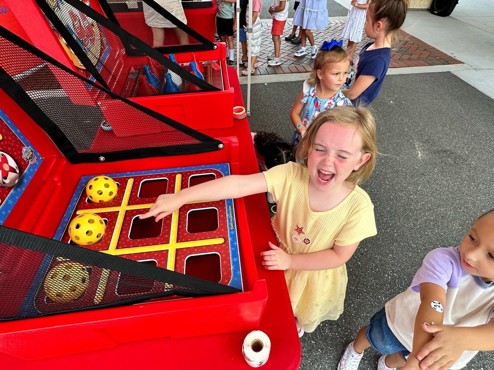 Kids smiling while playing tic-tac-toe and a carnival party