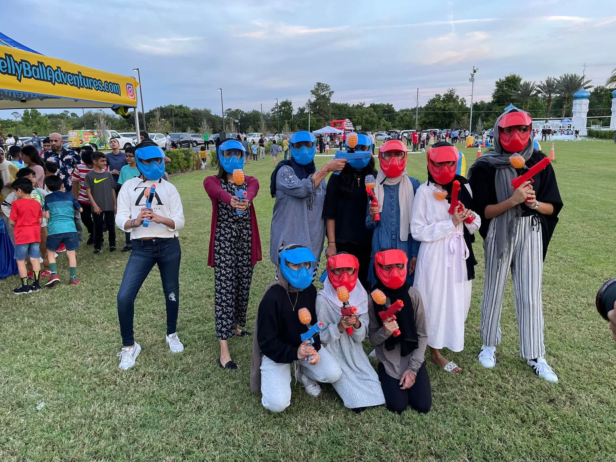 Players in red and blue masks at a community gellyball event