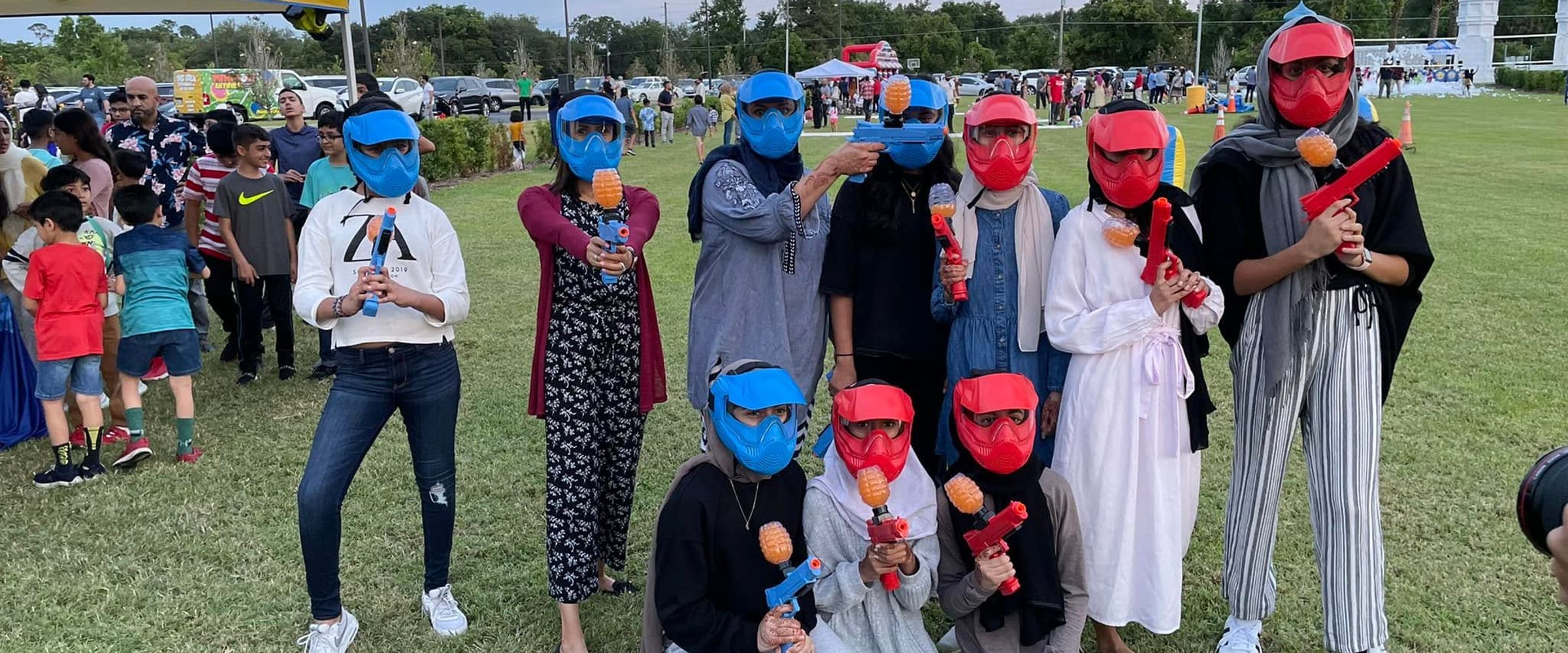 Players in red and blue masks at a community gellyball event