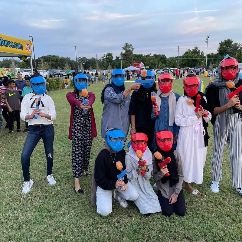 Players in red and blue masks at a community gellyball event