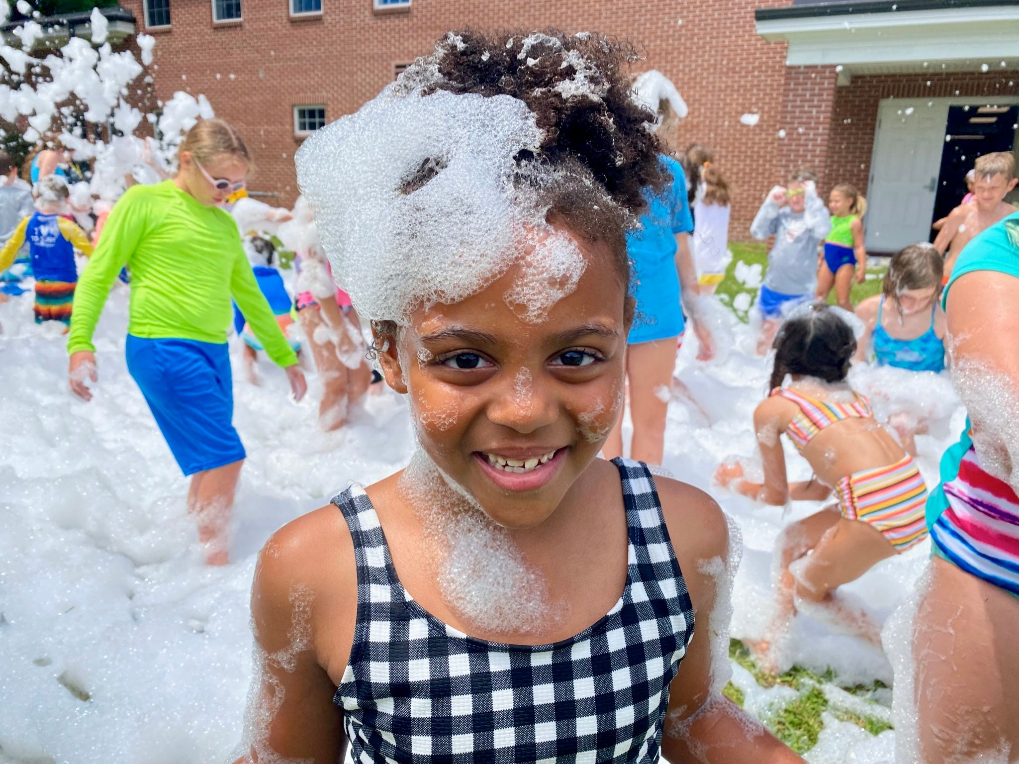 A girl smiling at a school foam party in Tampa Bay Florida