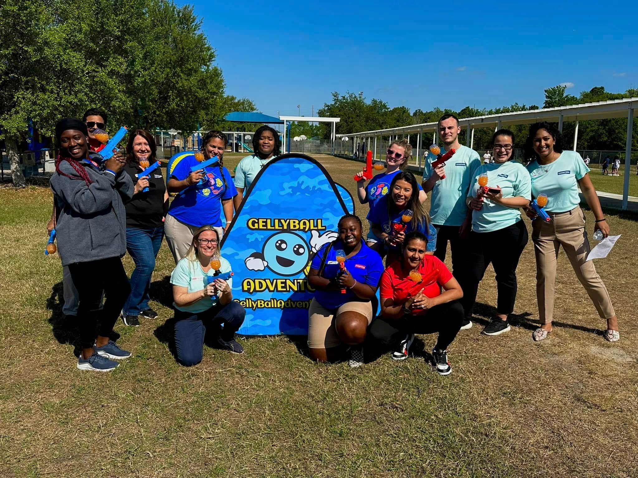 A team of adults posing around a Gellyball Adventures bunker