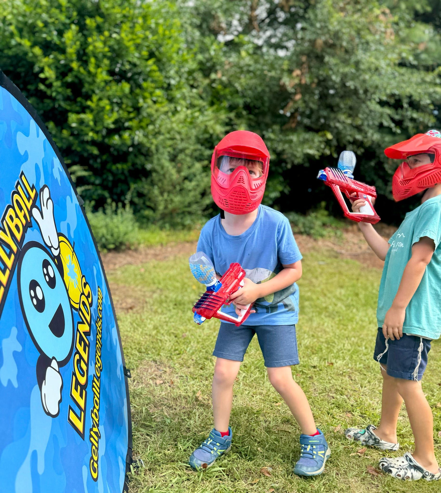 Two young players in red masks get ready for the next round beside a bunker