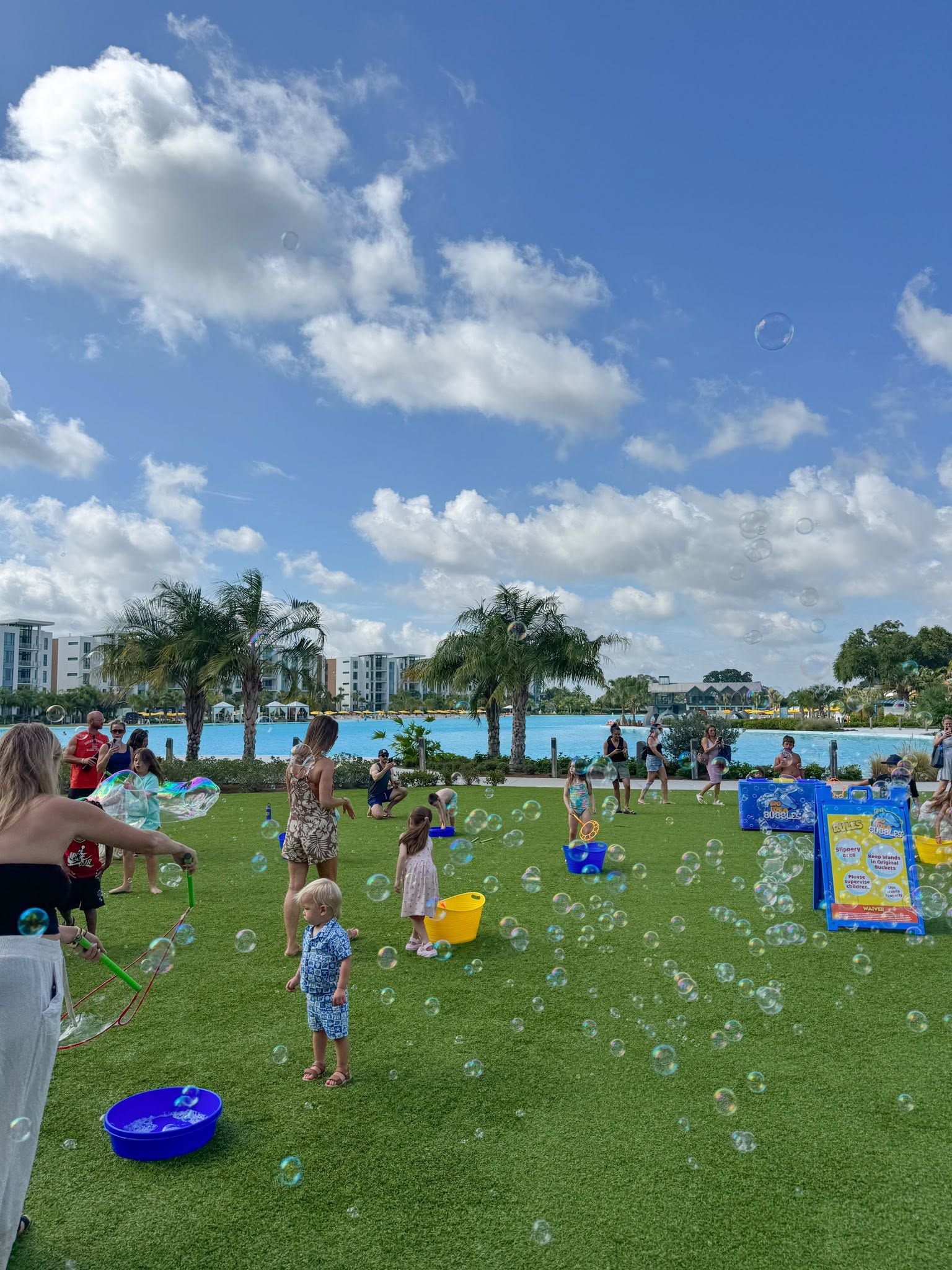 kids playing with bubbles on a resort lawn under a blue sky