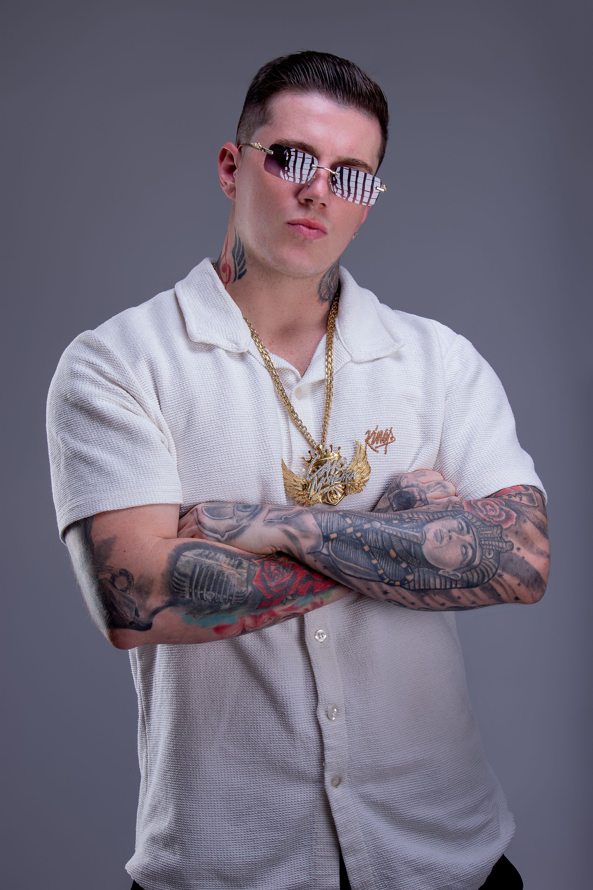DJ Caio Moreira de camisa branca e braços cruzados