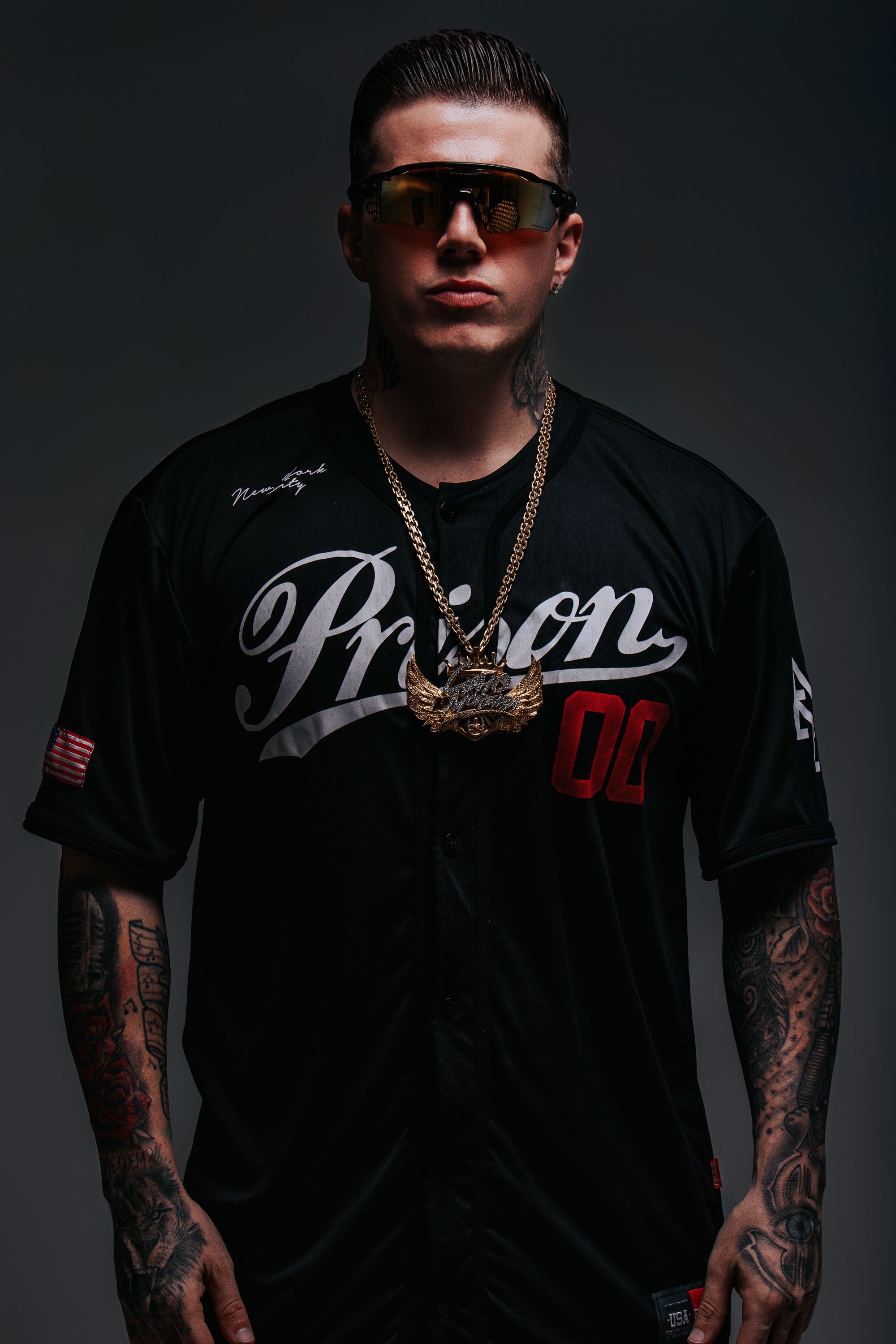 DJ Caio Moreira de óculos escuros e camisa preta em ensaio de estúdio