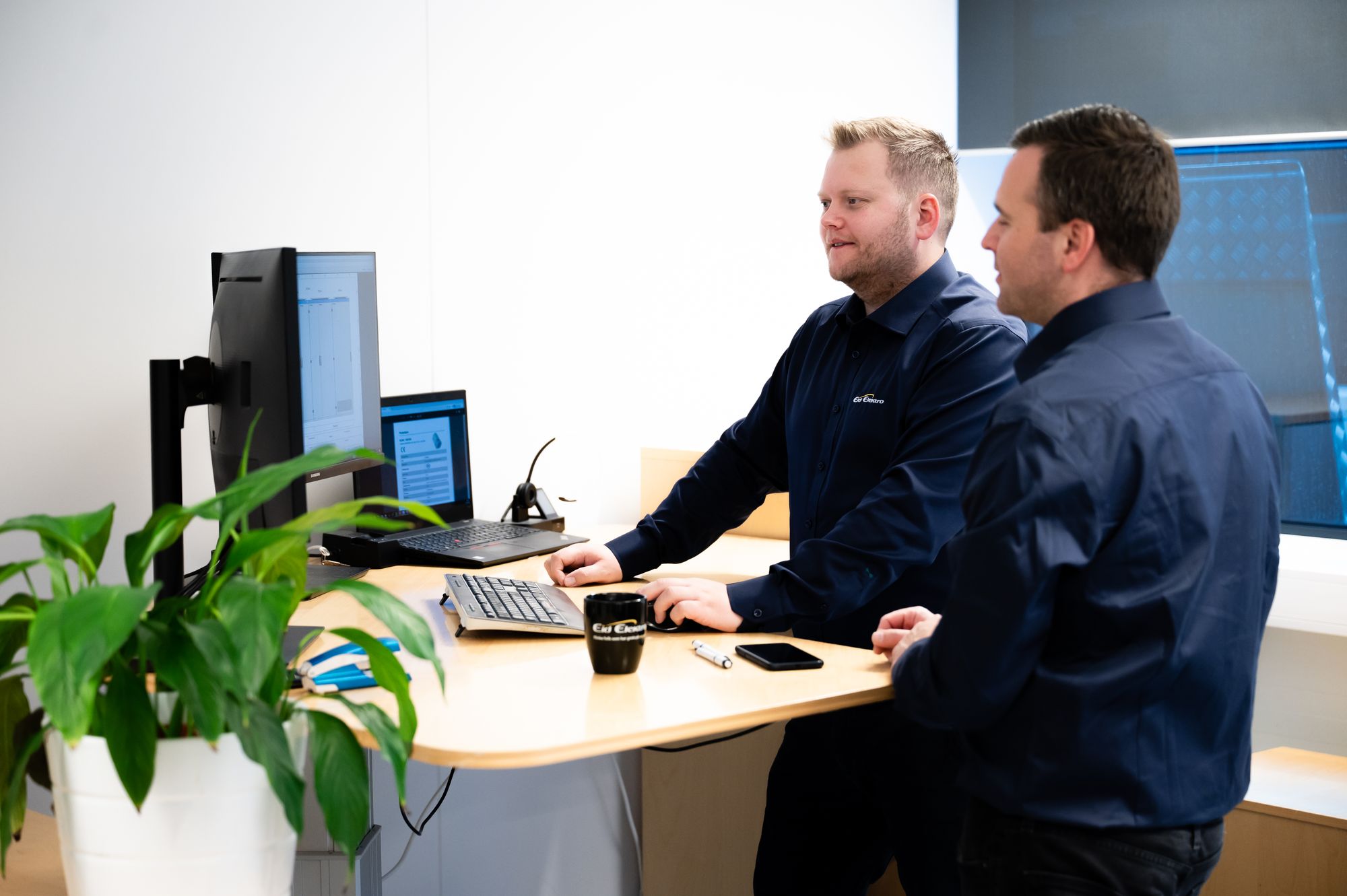 To ansatte på et kontor som ser på en PC-skjerm