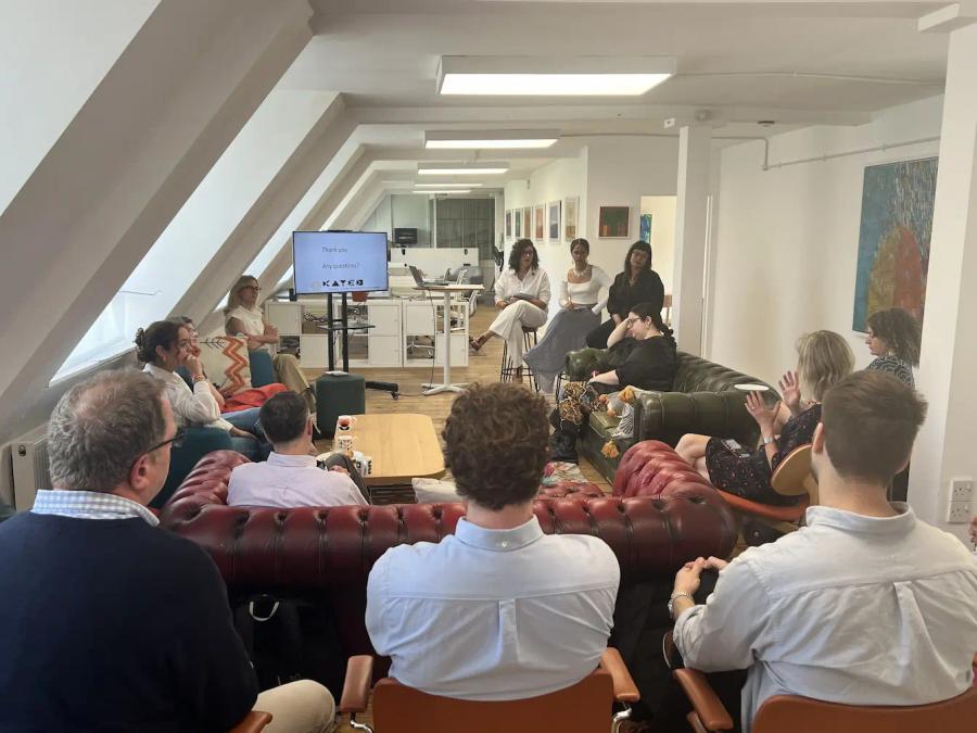 Audience in semi-circle asking questions to the guest speakers