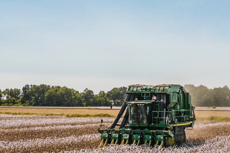 A tractor harvesting plants on a farm