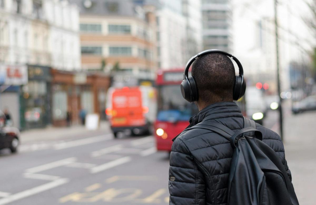 male listening to podcast on busy road