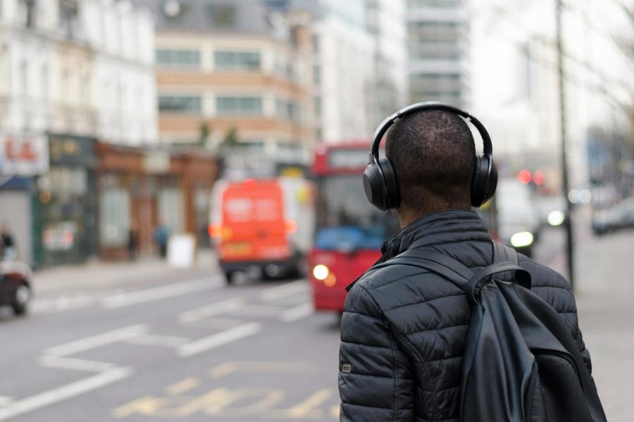 male listening to podcast on busy road