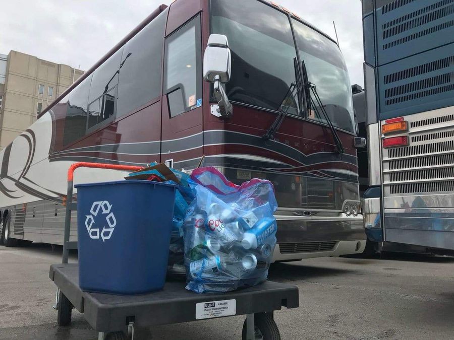 Recycling bags in front of a tour bus.