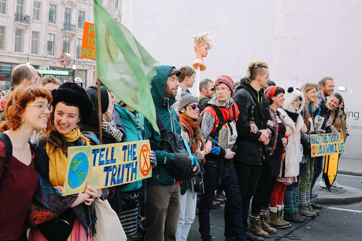 People lining up for the International Rebellion, holding placards and banners.