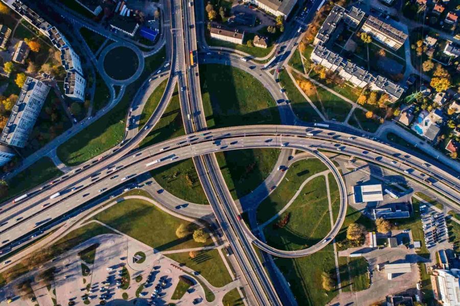 Aerial photo of multiple highways above a green park.