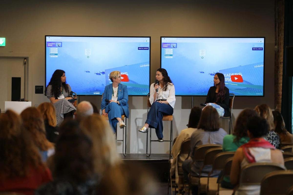 Four women panelists sit on stage in front of a "Leaders 2050" backdrop, discussing future leadership while an audience listens attentively.