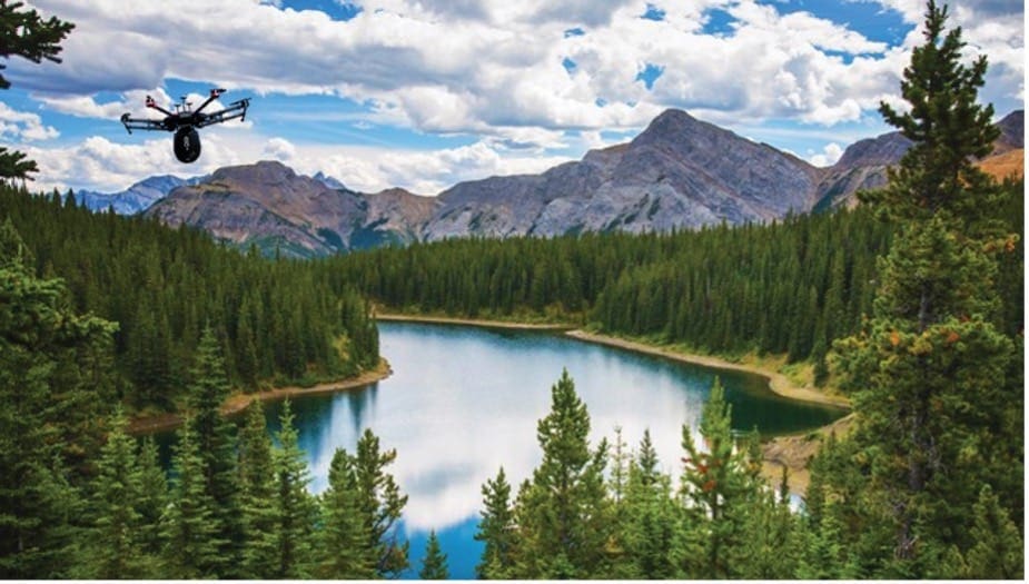 Drone flying over a river with mountains in the background.