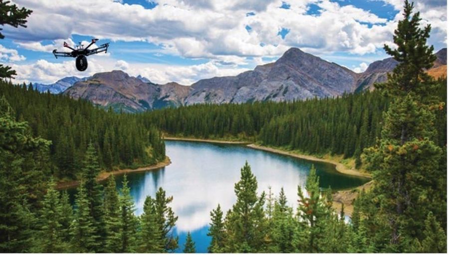 Drone flying over a river with mountains in the background.