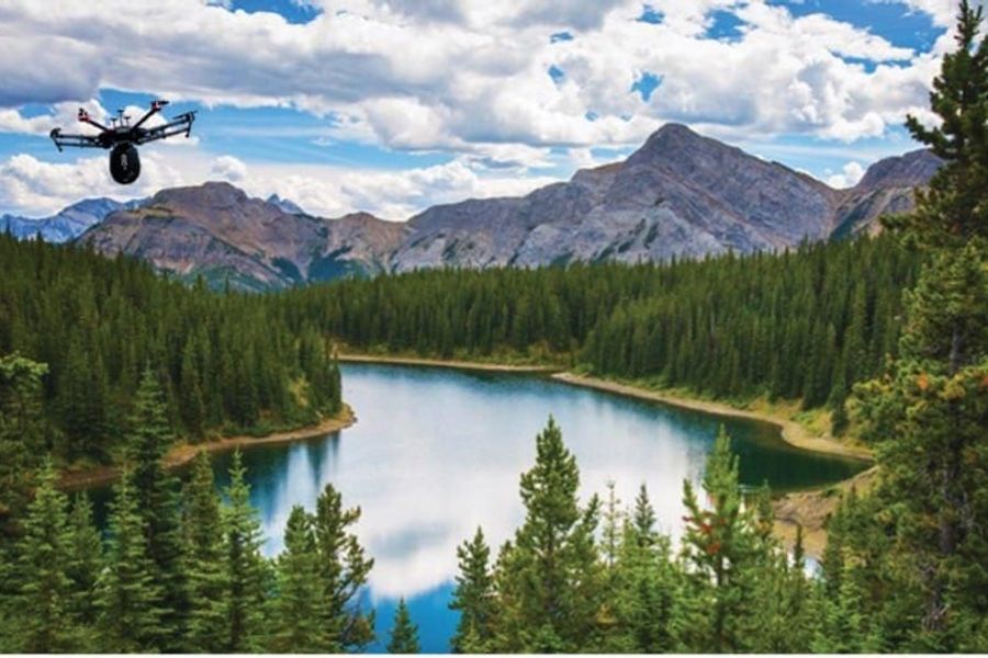 Drone flying over a river with mountains in the background.