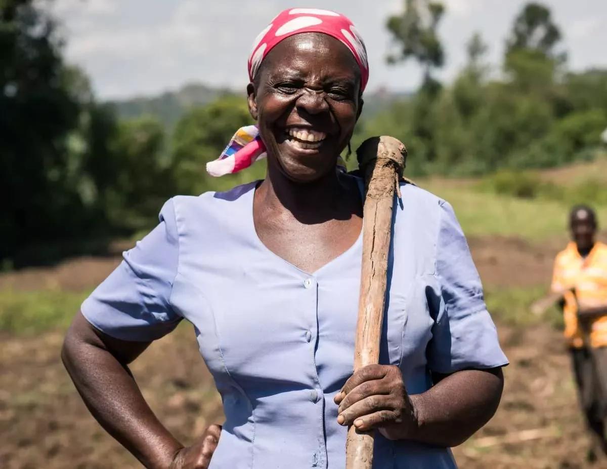 A female smallholder farmer from in Sub-Saharan Africa smiling into the camera