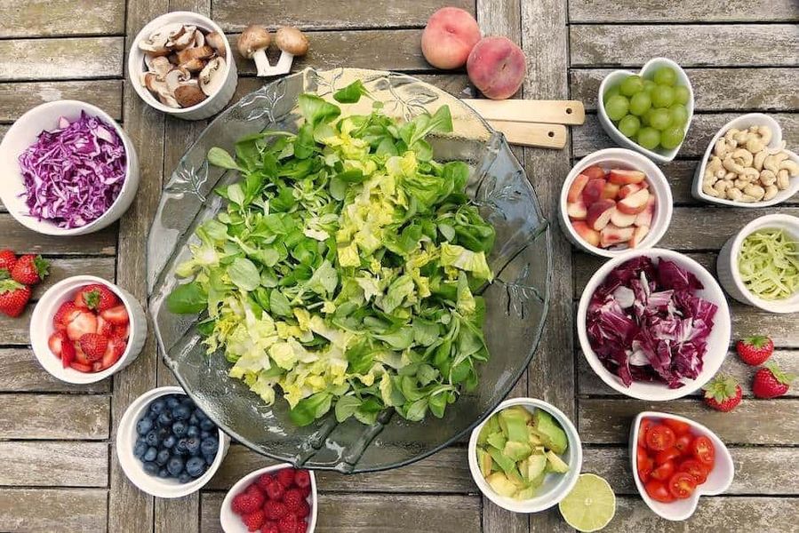 Bowls of fruit and salad on table