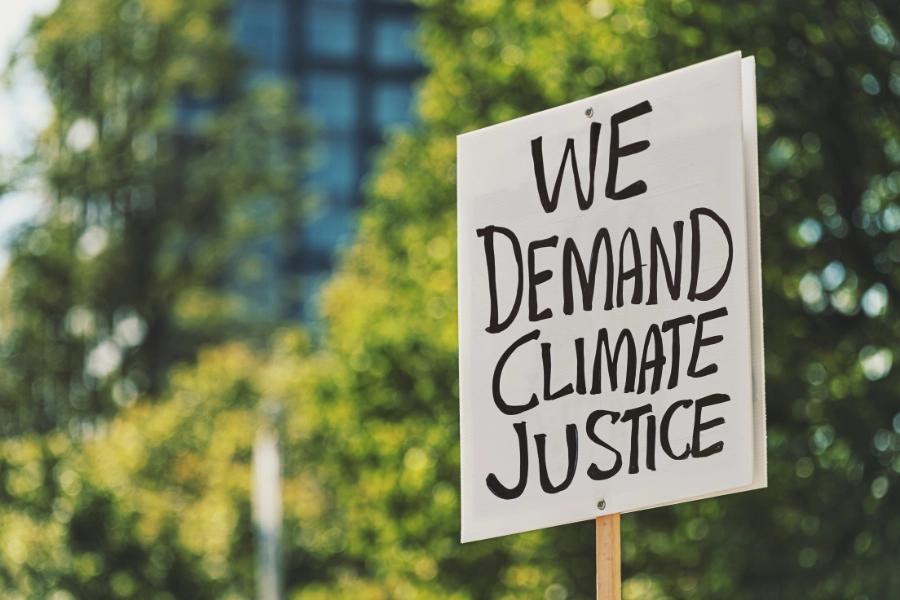 Why we need millions of imperfect activitsts. Image shows a placard reading: We demands climate justice.