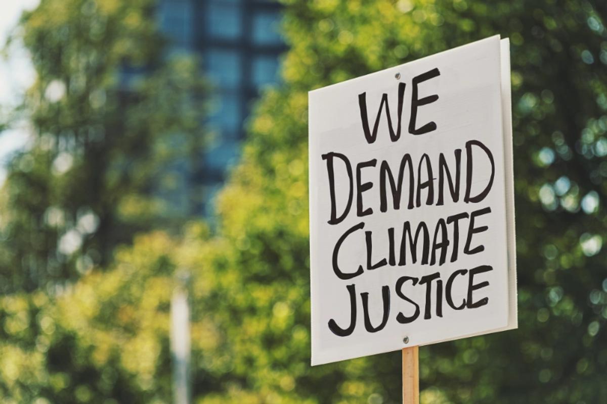 Why we need millions of imperfect activitsts. Image shows a placard reading: We demands climate justice.