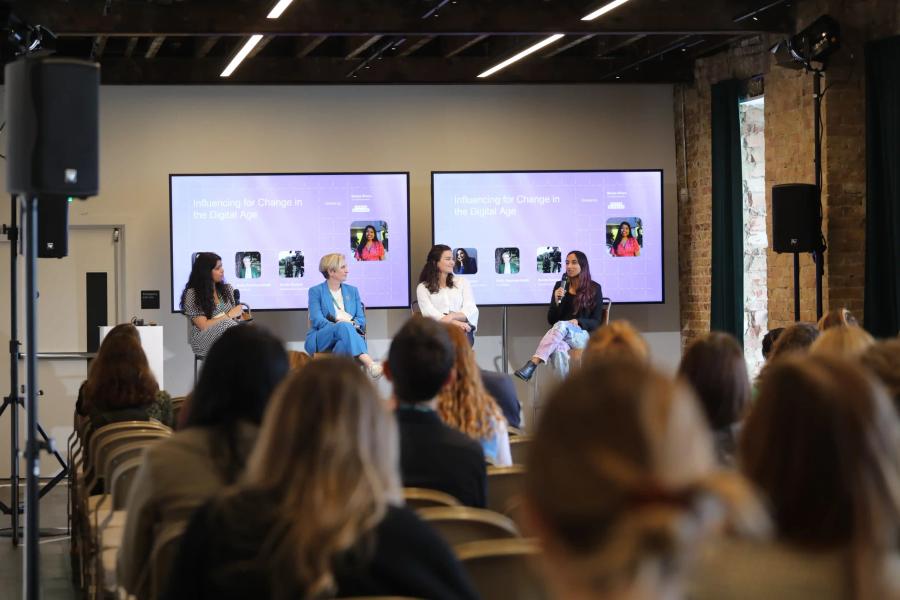 Four women panelists sit on stage in front of a "Leaders 2050" backdrop, discussing future leadership while an audience listens attentively.