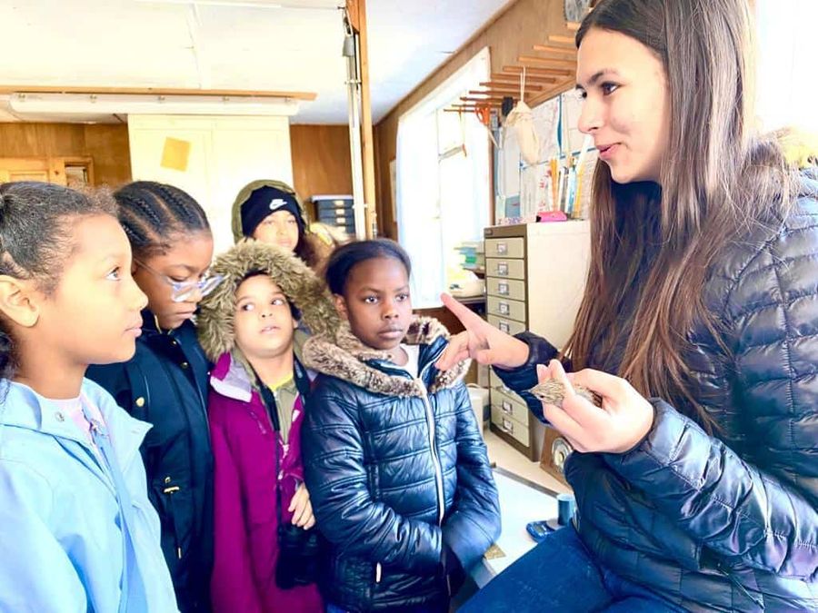 Women holding bird and showing it to 5 young girls