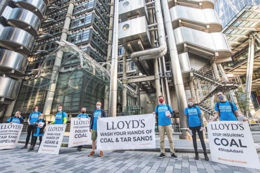 Activists stand in front of Lloyds Bank London with signs demanding an end to their involvement in coal and tar activities