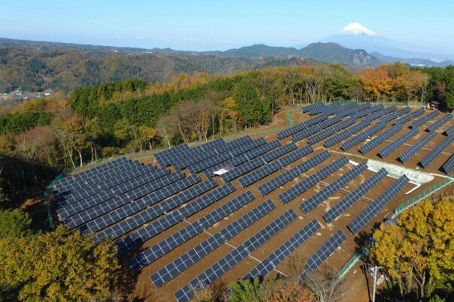 How tandem solar cells will change the world. Image shows solar cells in a field with a mountain in the distance background