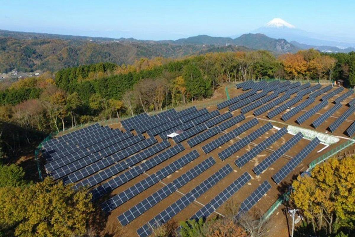 How tandem solar cells will change the world. Image shows solar cells in a field with a mountain in the distance background
