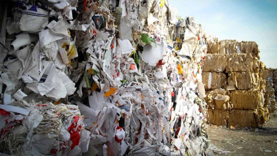 Bales of plastic rubbish stacked in a yard.