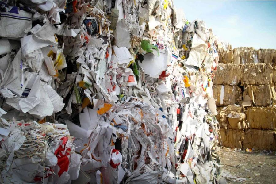 Bales of plastic rubbish stacked in a yard.