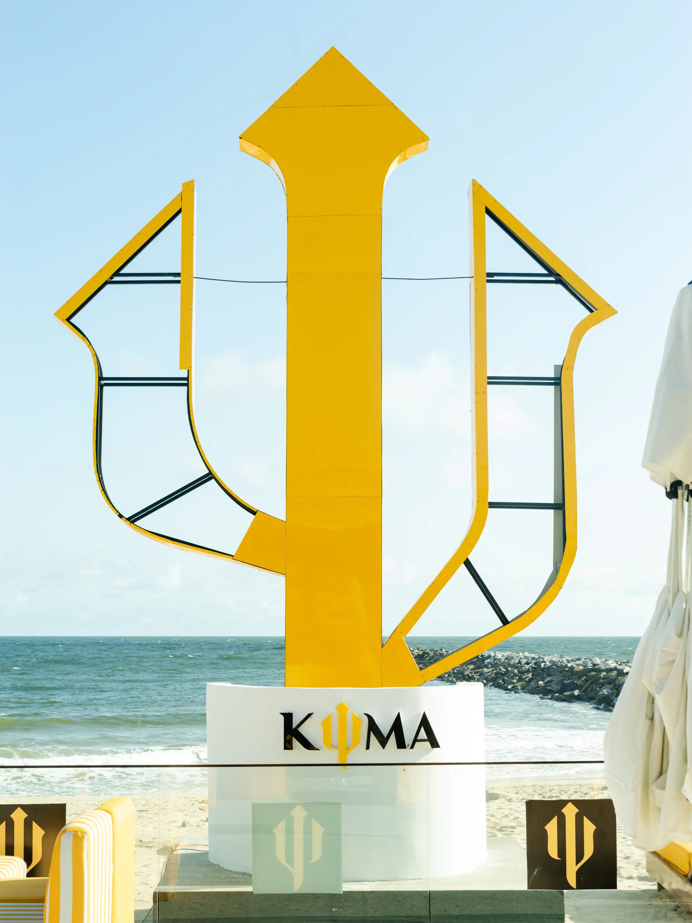 The saffron trident sculpture against the Atlantic
