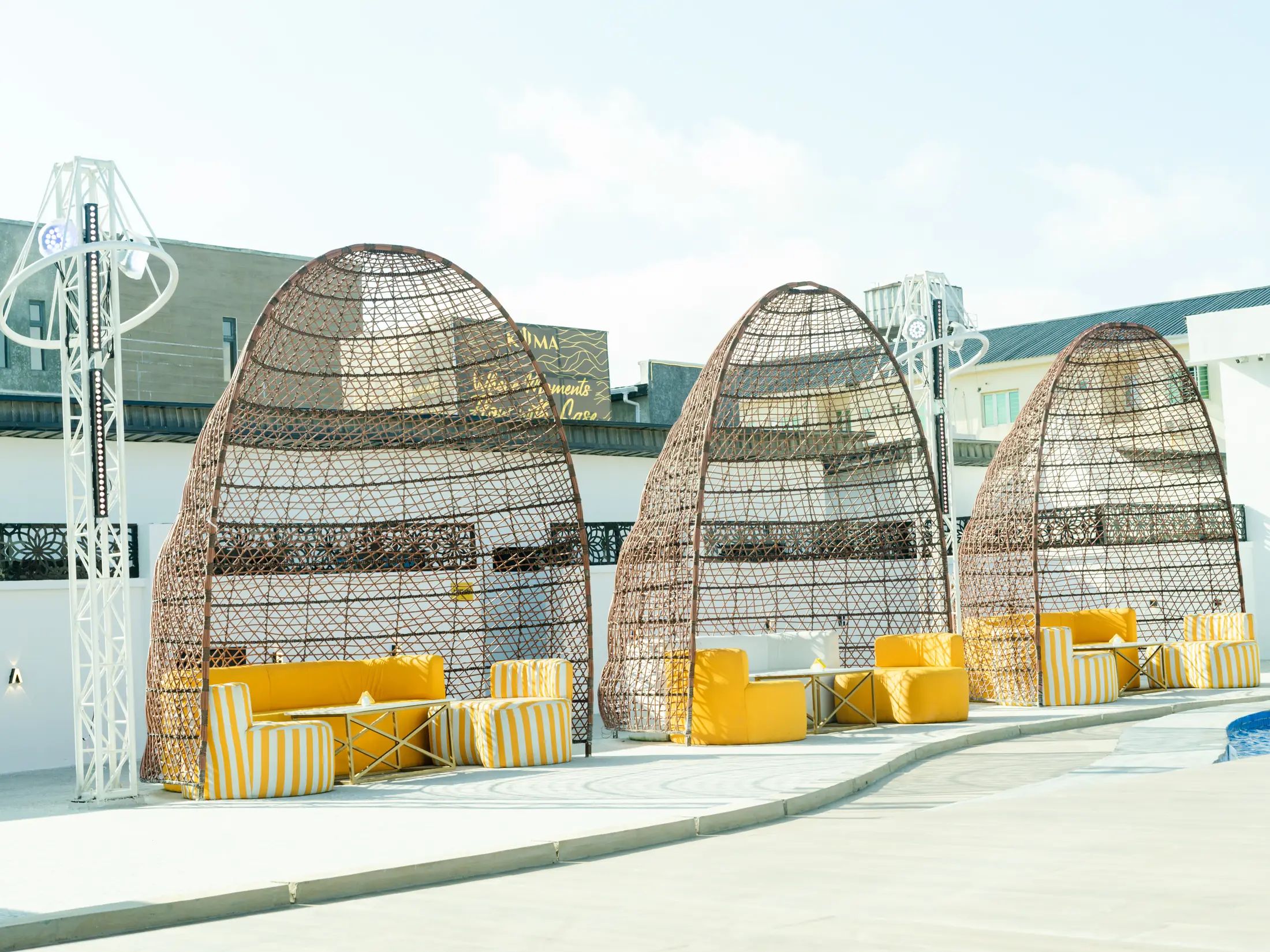 A row of woven cabana domes along the pool