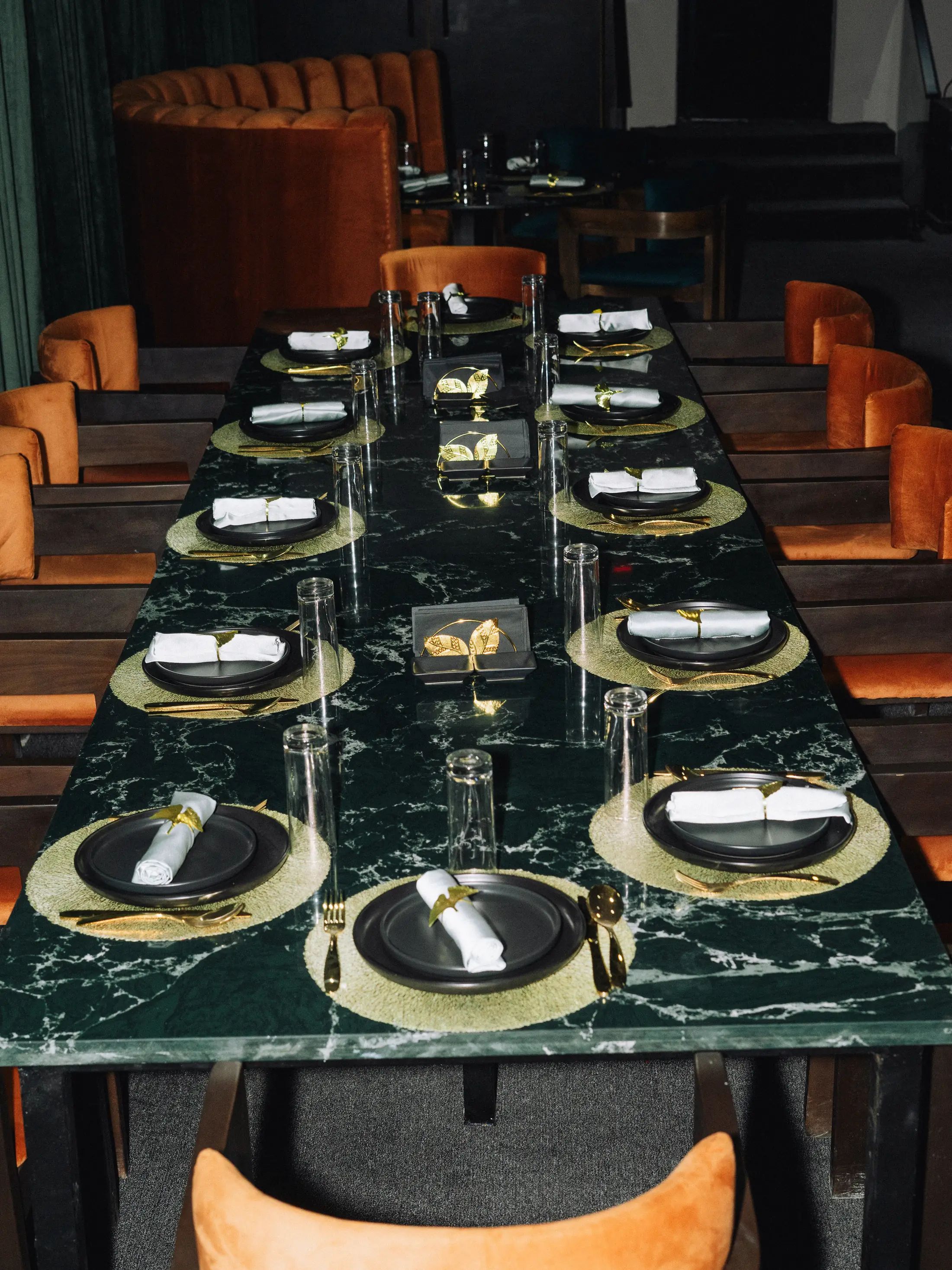 Green marble tables and velvet banquettes at LYA