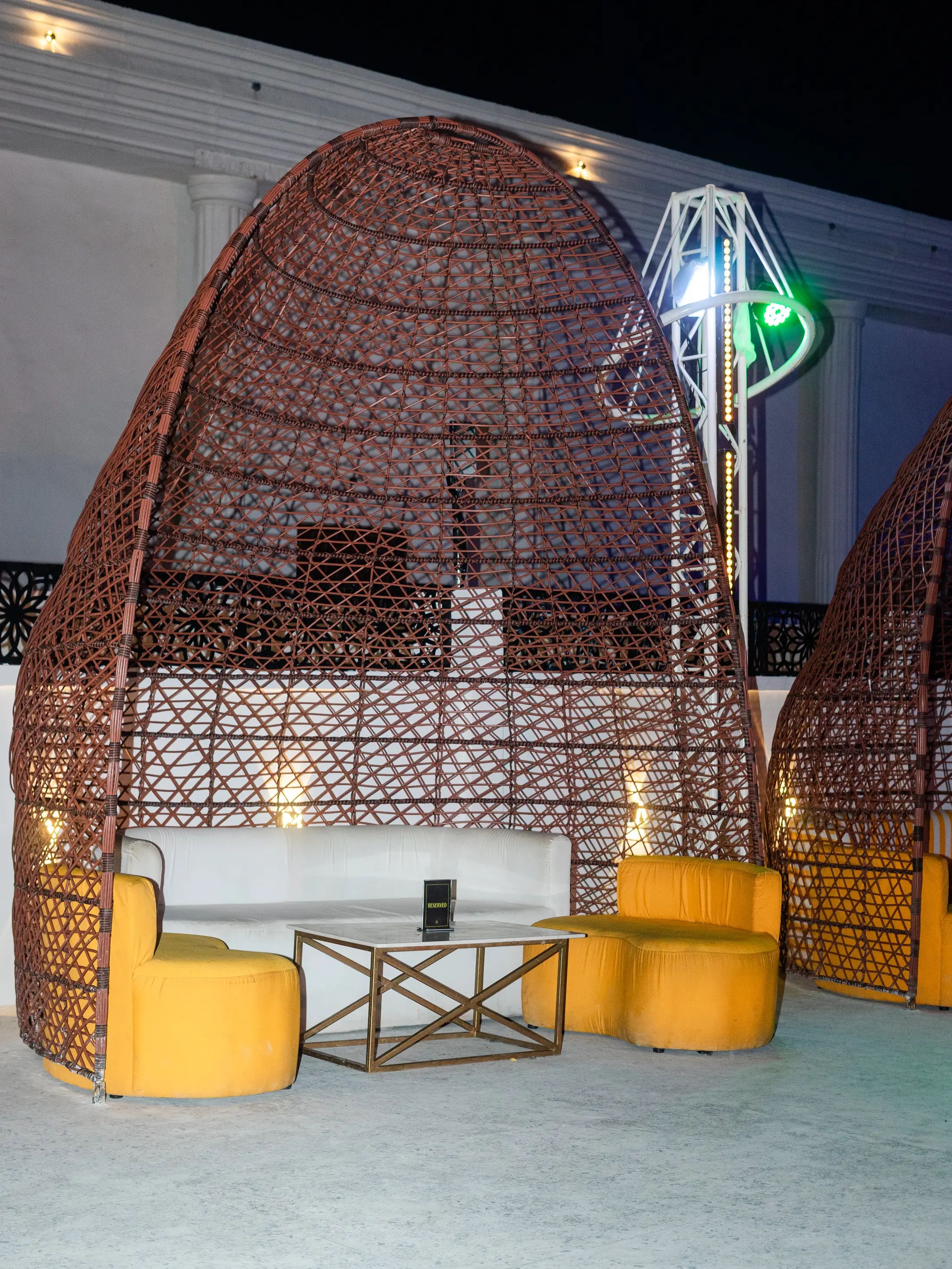 A lit cabana with saffron seating at night