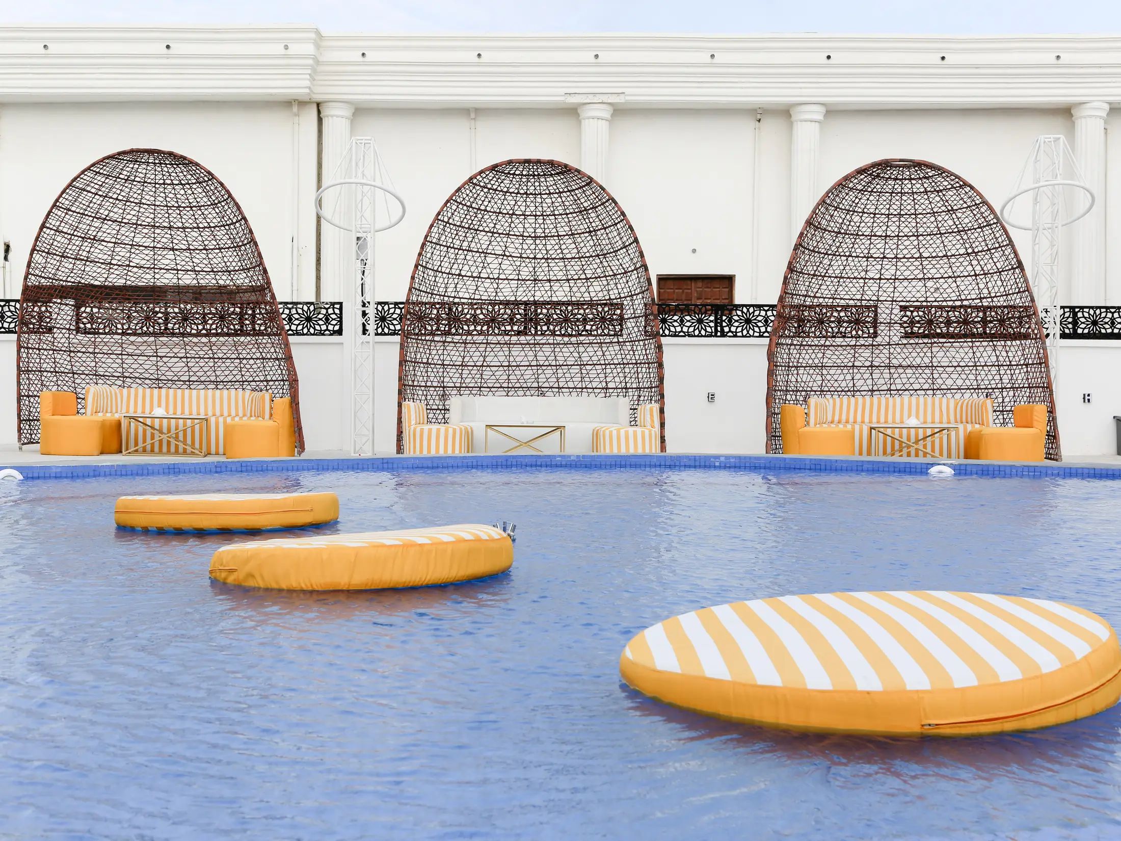 The pool at KYMA with saffron floats and cabana domes behind