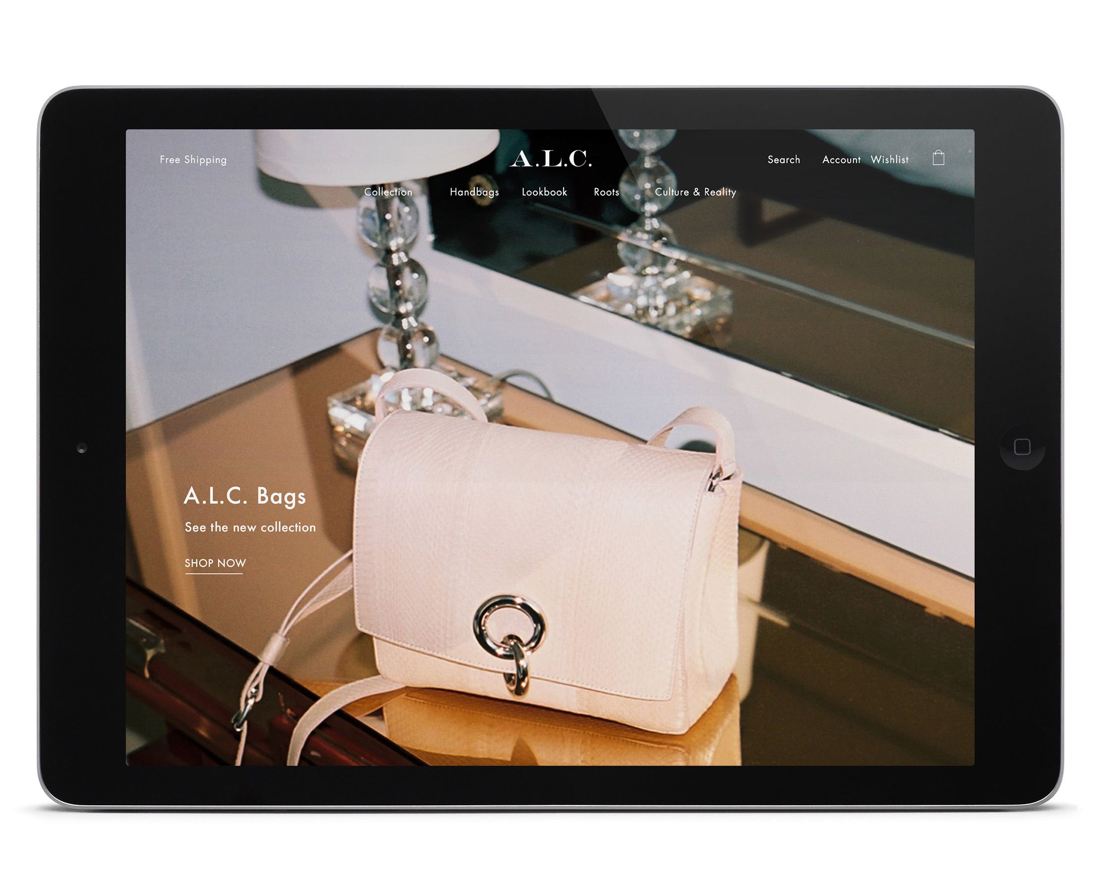 A pink handbag resting on a glass-top side table beside a small lamp