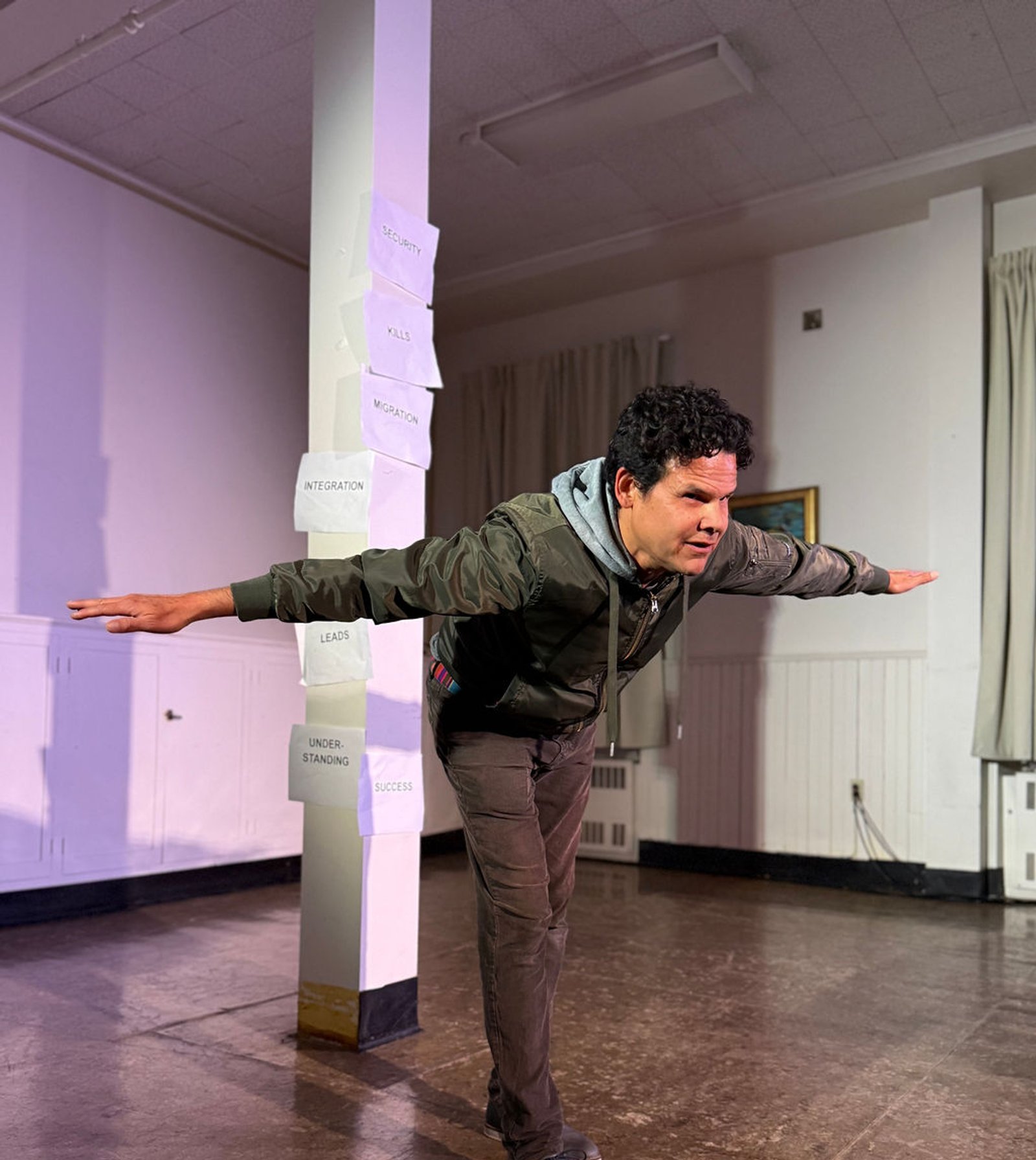 Diego López standing on one foot with his arms ourstretched. by Casey Marie Ecker.