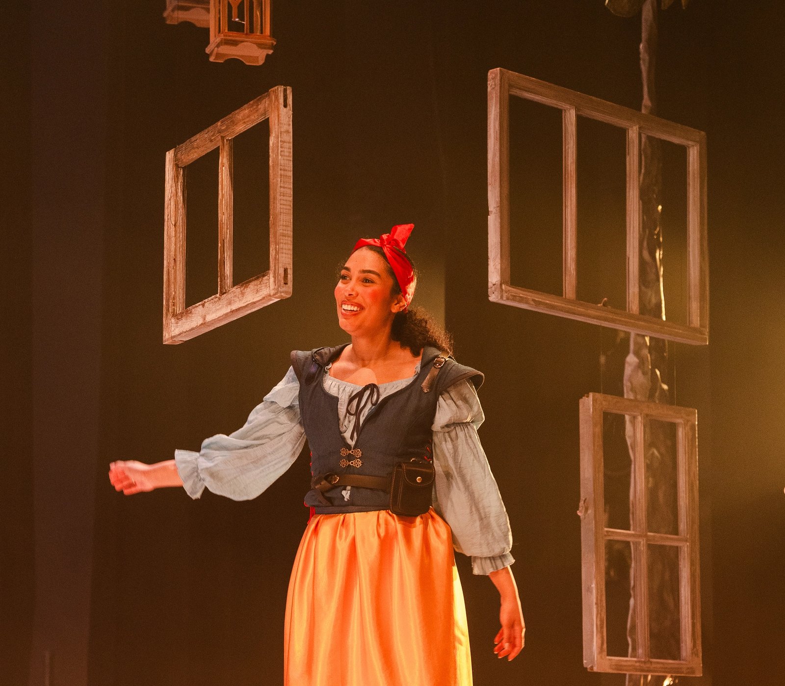 Tiernan Cornford, as Snow White, standing on top of a box surrounded by window frames.