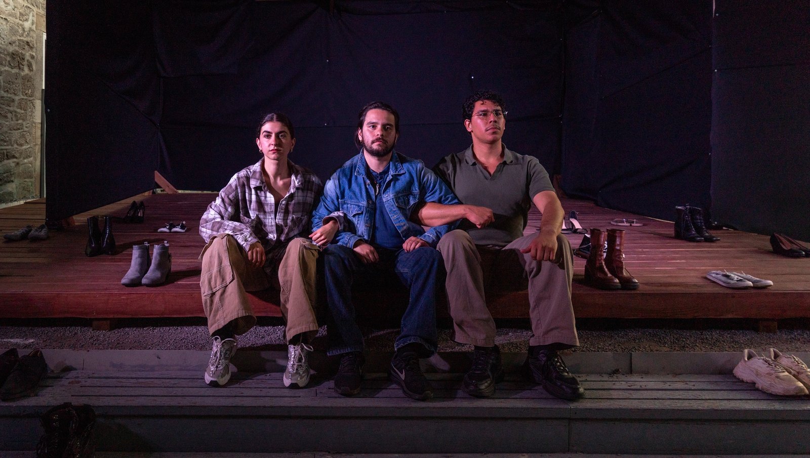 performers Julia Pye, Sebastian Quint, and Joshua Bilbao putting on their shoes