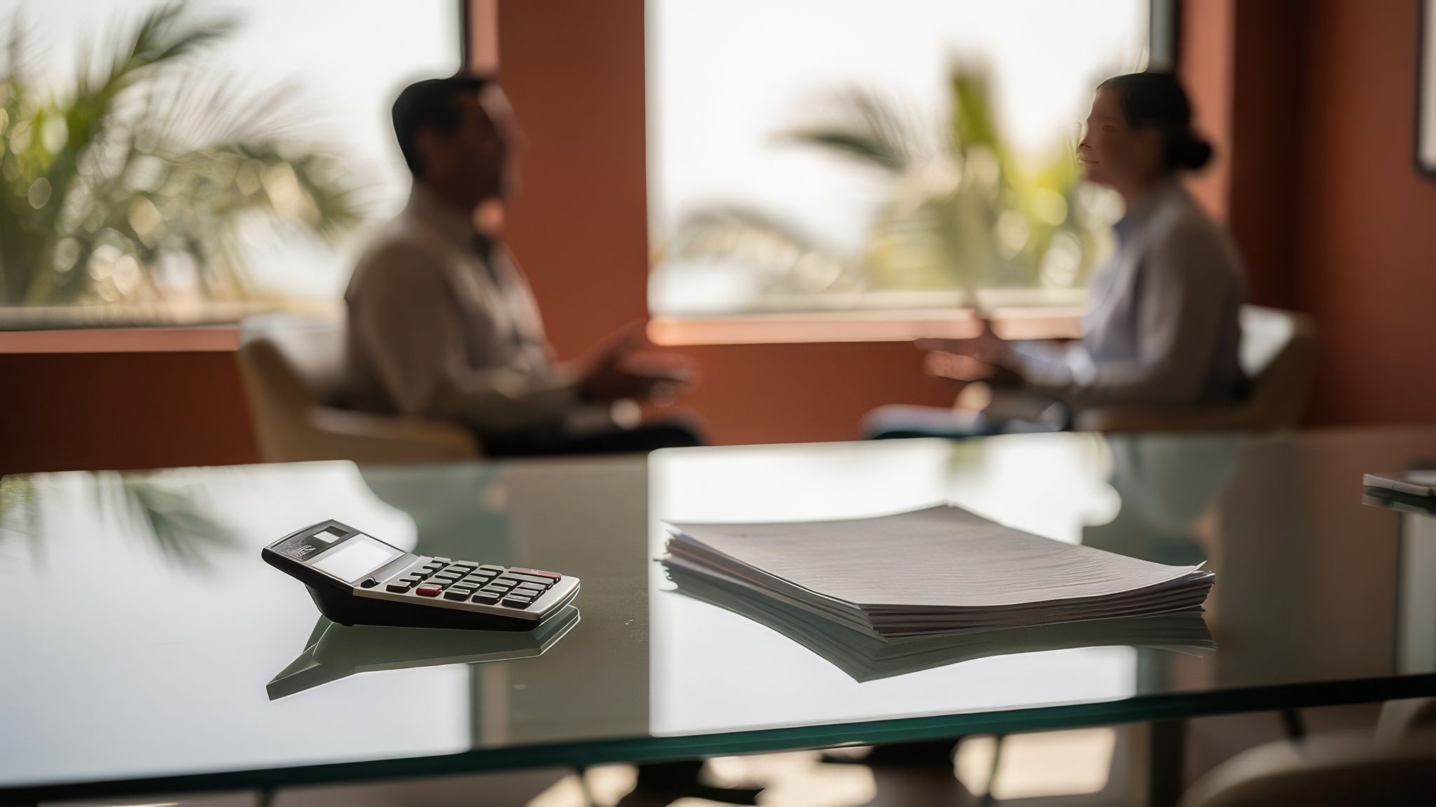A California clinic-style consultation scene with planning documents on a glass table.