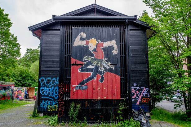 A big painting of a man dancing his heart out to some ska-music, on the wall of a house