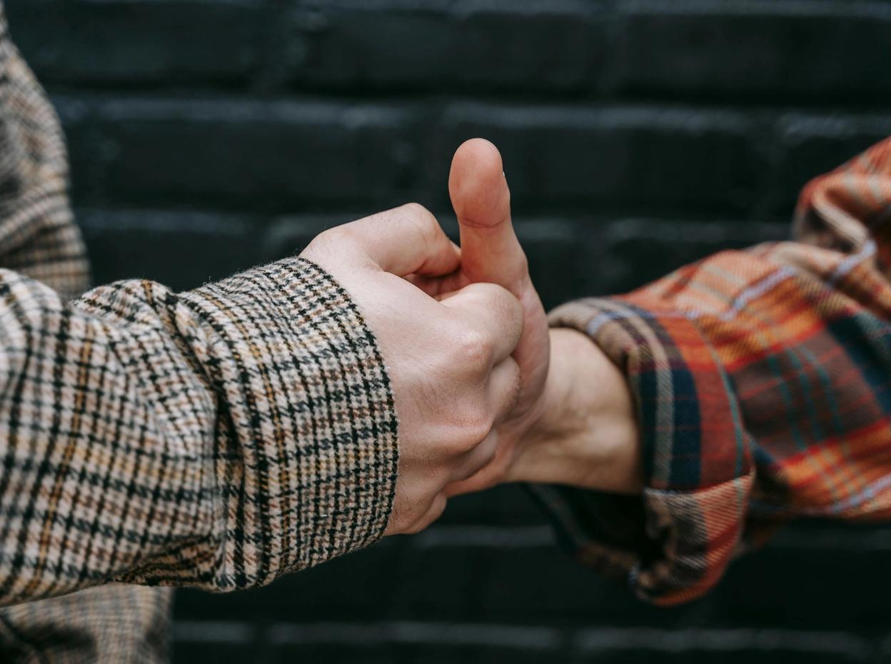 Two men battling it out in a game of thumb wars