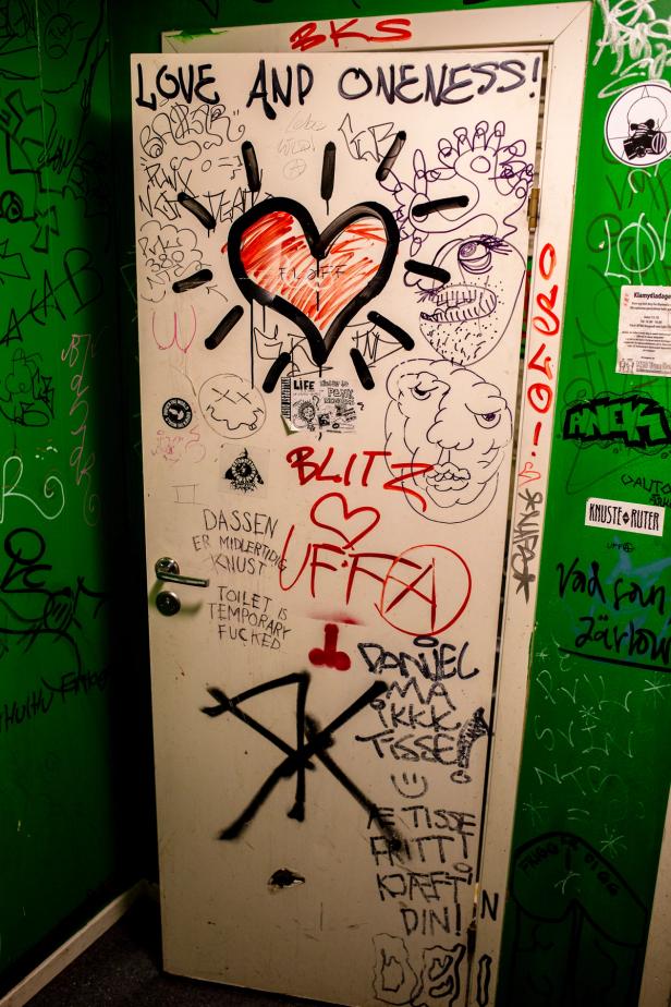 A white door with graffiti and writings on it