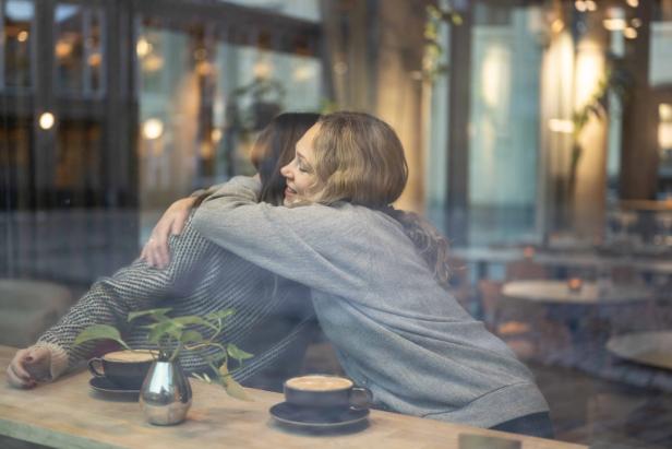 Jaya and McKenna hugging at café